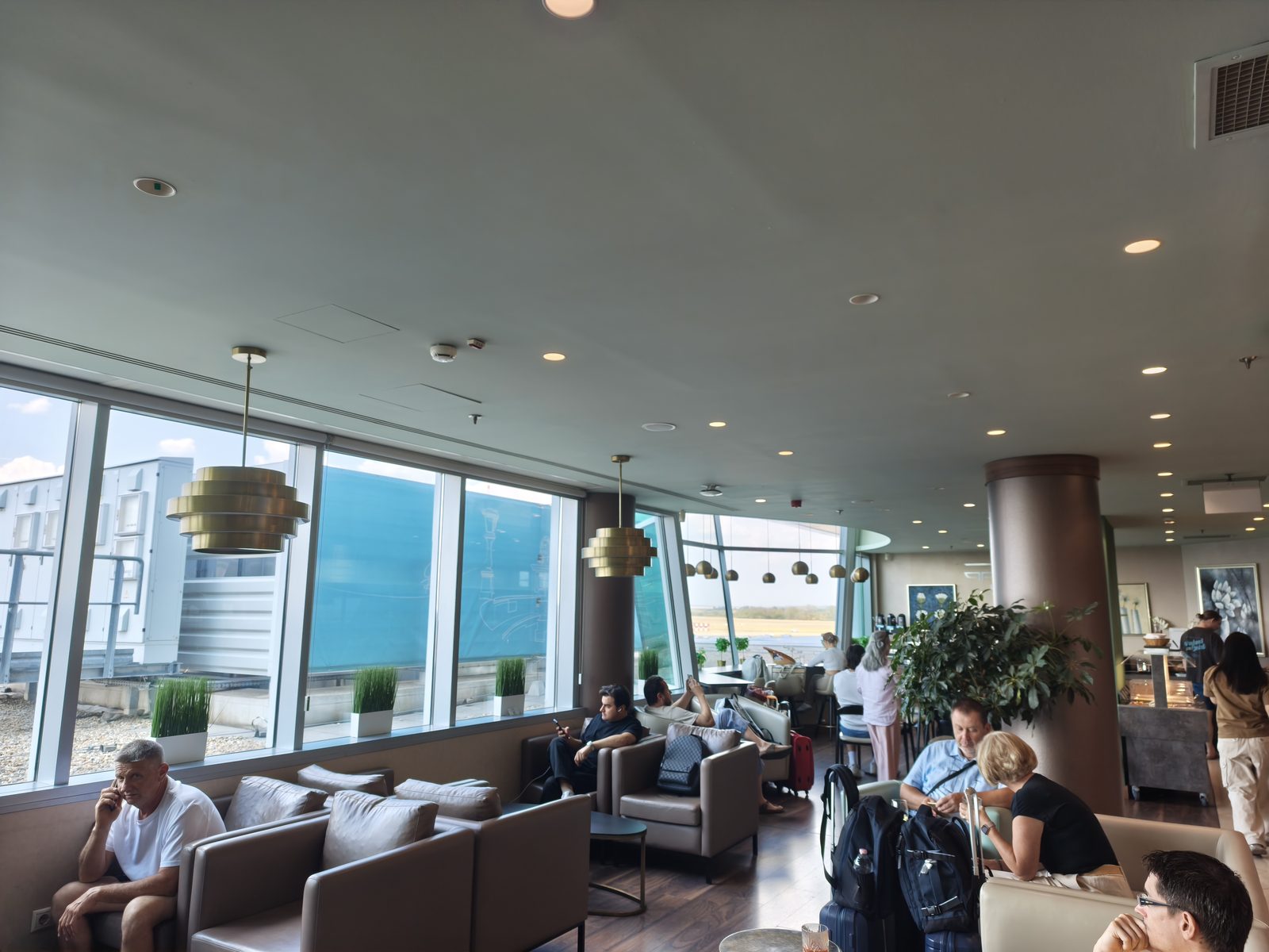 Platinum Lounge（Non-Schengen）の客席エリア。窓際にソファ席が並び、多くの席が埋まっている