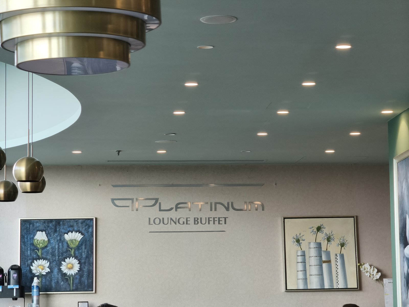 PLATINUM LOUNGE BUFFETのサインと、ミントグリーンの天井にゴールドの照明が並ぶ内装